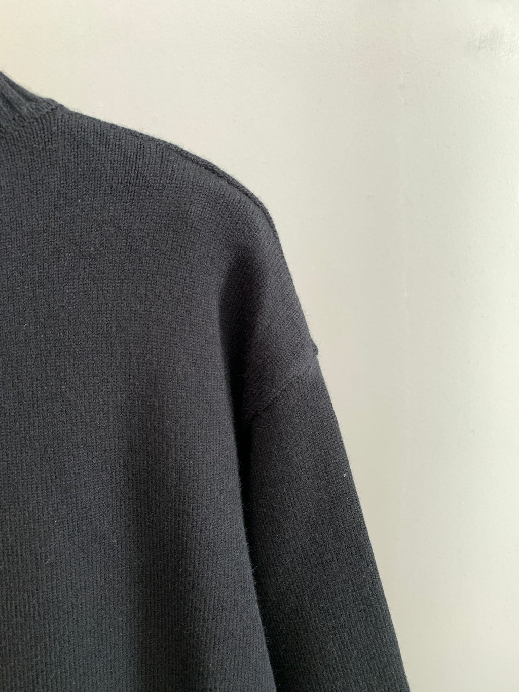 Dark knit sweater shoulder and sleeve with ribbed crewneck trim