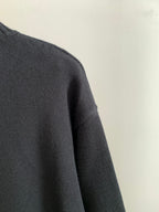 Dark knit sweater shoulder and sleeve with ribbed crewneck trim