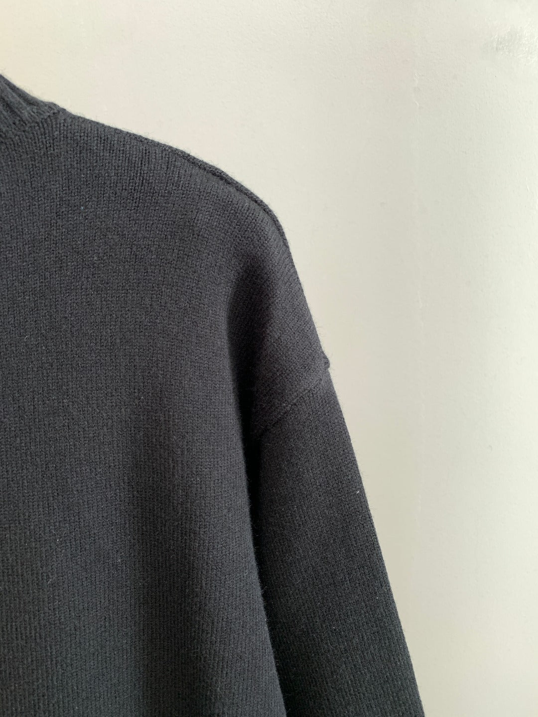 Dark knit sweater shoulder and sleeve with ribbed crewneck trim