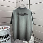 Light gray short-sleeve T-shirt with Christian Dior logo print on back.