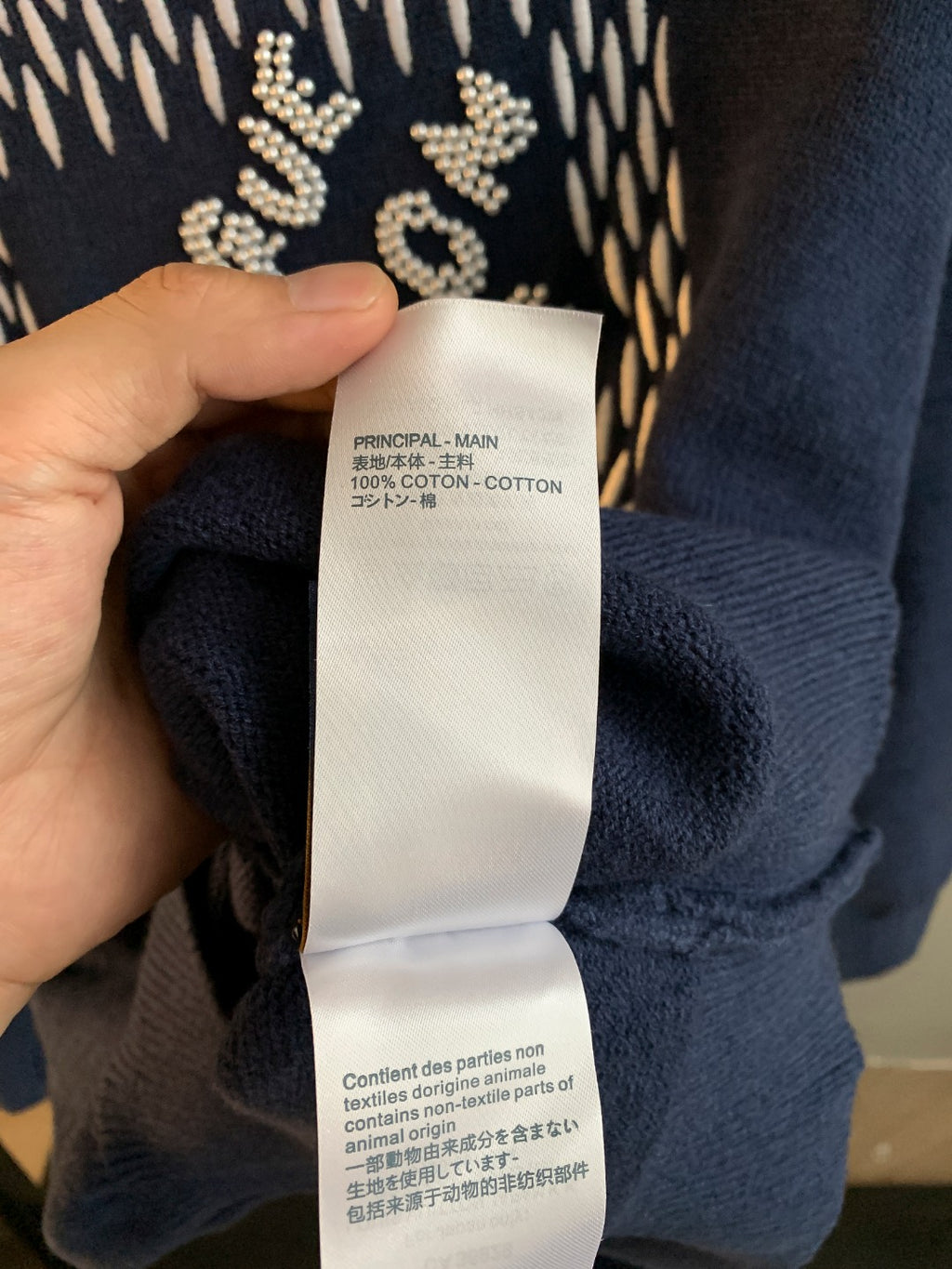 Navy blue knit sweater showing care label at inner collar