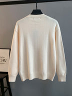 Cream knit long-sleeve crewneck sweater on hanger, ribbed collar and cuffs