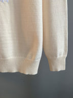 Cream knit sweater hem and long sleeves with ribbed cuffs