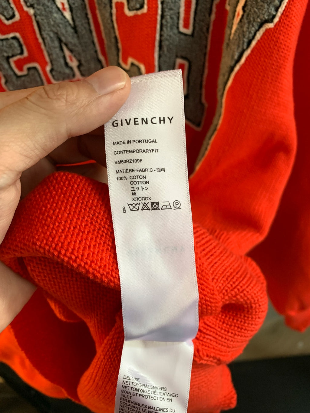 Givenchy red sweater care label with Made in Portugal and cotton blend info