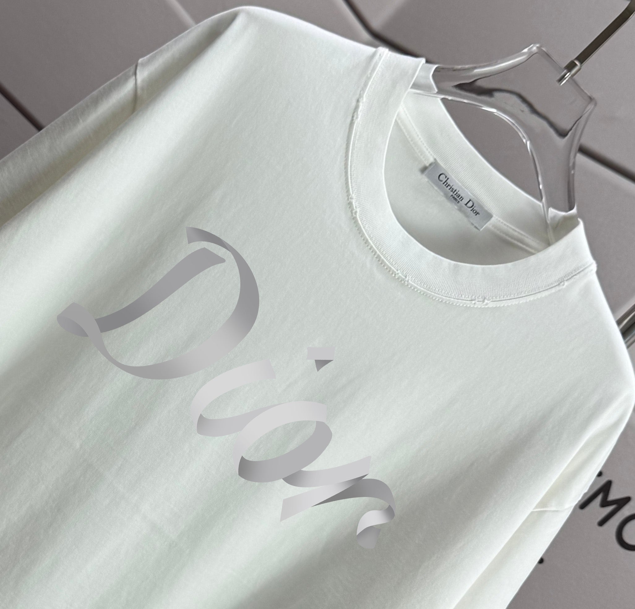 White Dior T-shirt neckline with small logo tag and 'Dior' print detail