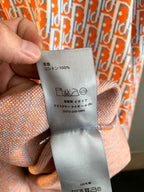 Dior logo-print shirt care label showing “100%” and icons on gray tab