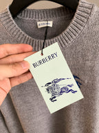 Heather gray knit sweater with ribbed crew neck and hanging Burberry tag