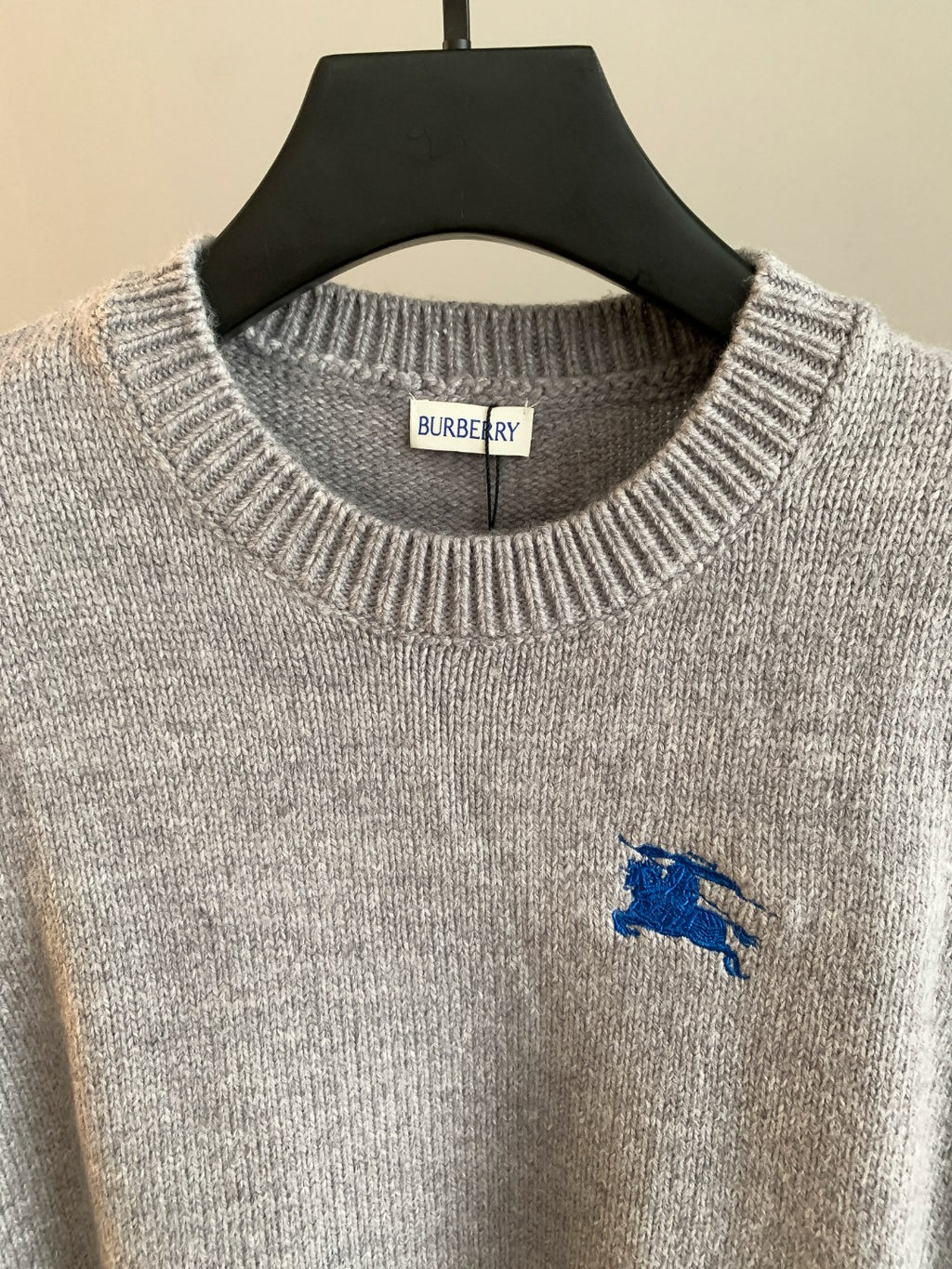 Heather gray knit sweater with ribbed crew neck, Burberry neck label, and blue horse