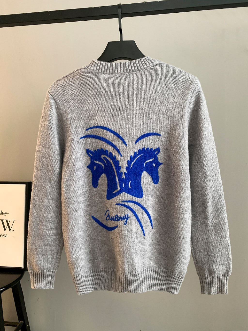 Gray crewneck knit sweater with large blue horse logo on the back, long sleeves