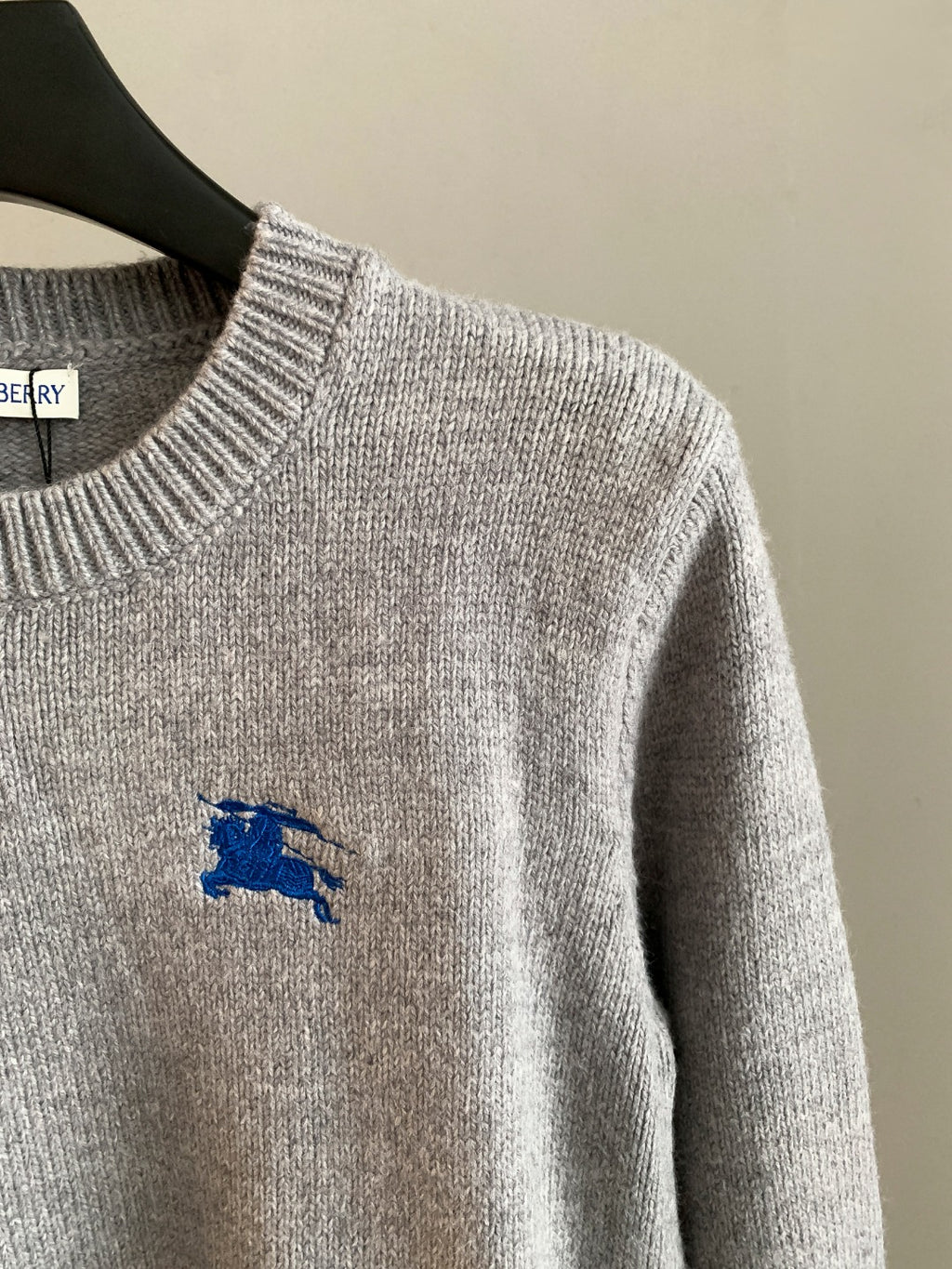 Heather gray knit sweater with long sleeve and small blue horse logo