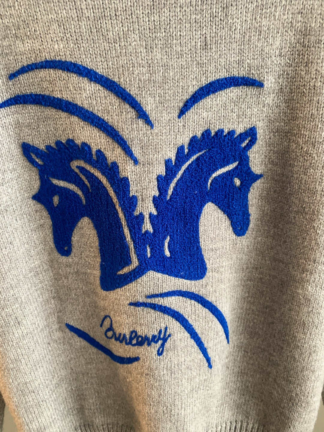 Heather gray knit sweater with large blue horse emblem graphic