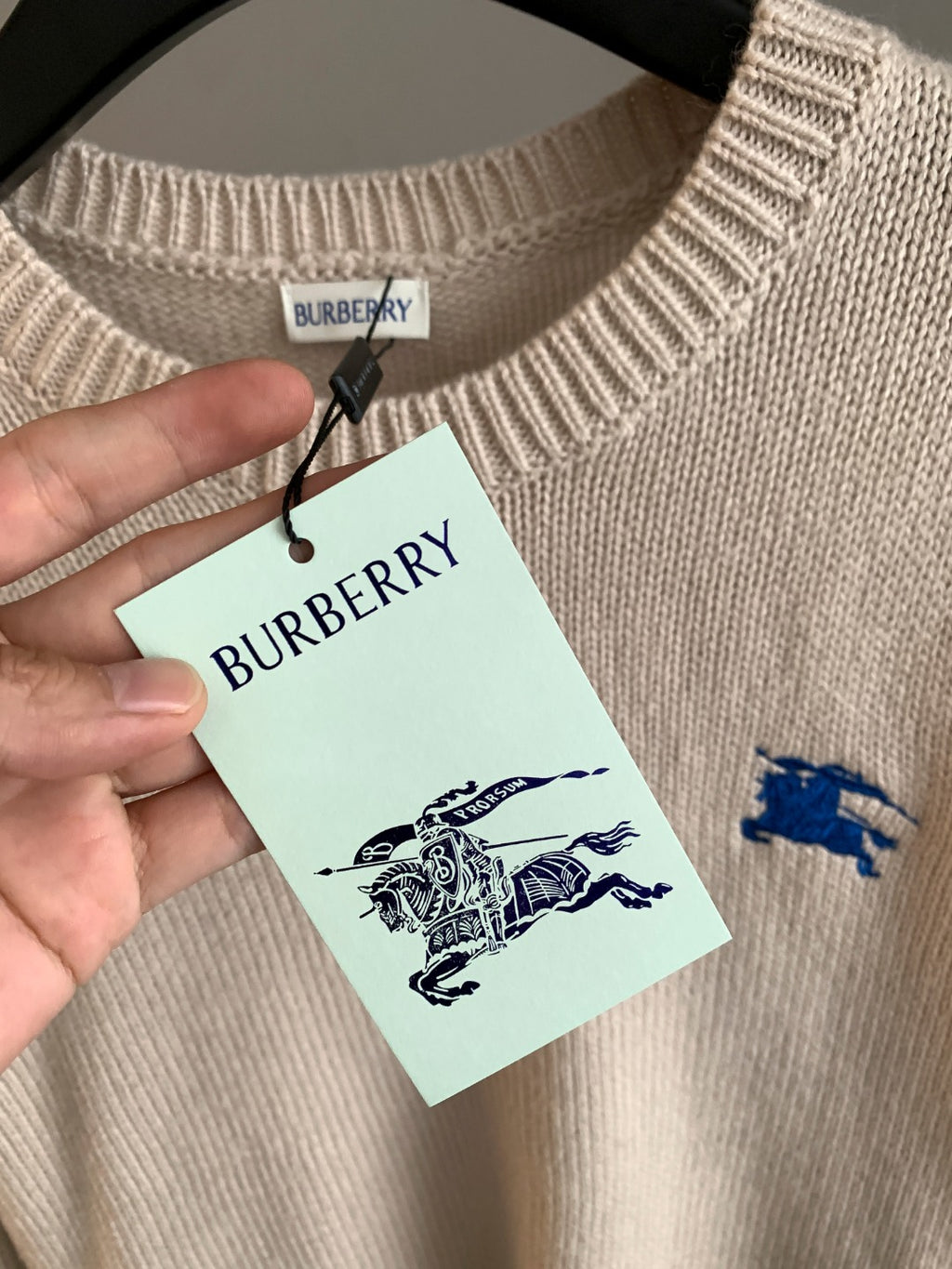 Cream knit sweater collar with Burberry tag and blue horse logo detail