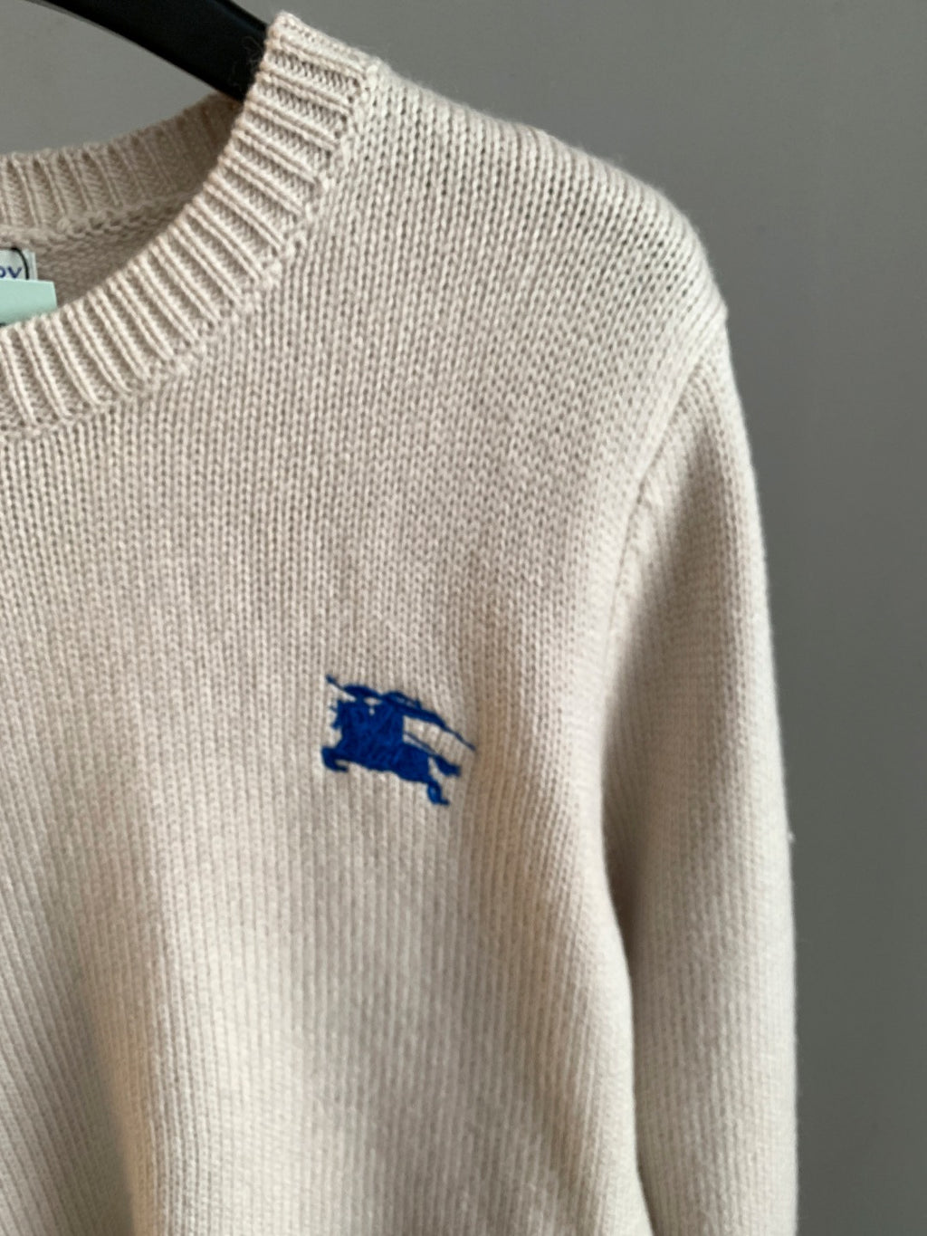 Cream knit long sweater with small blue horse logo on sleeve