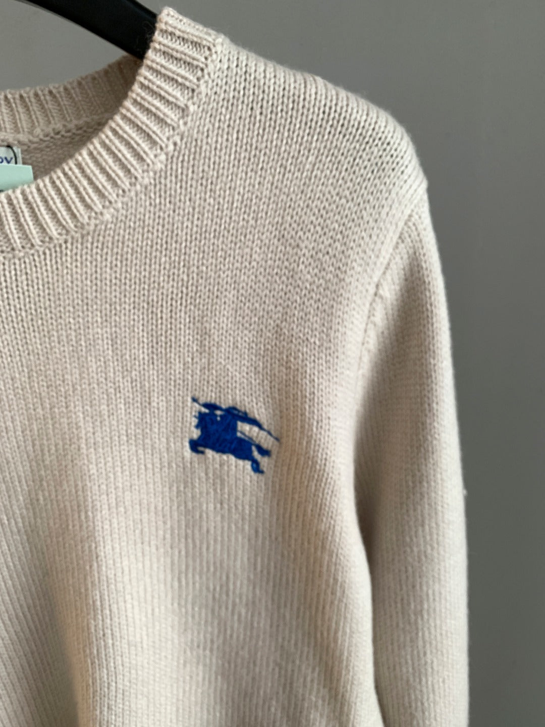 Cream knit long sweater with small blue horse logo on sleeve