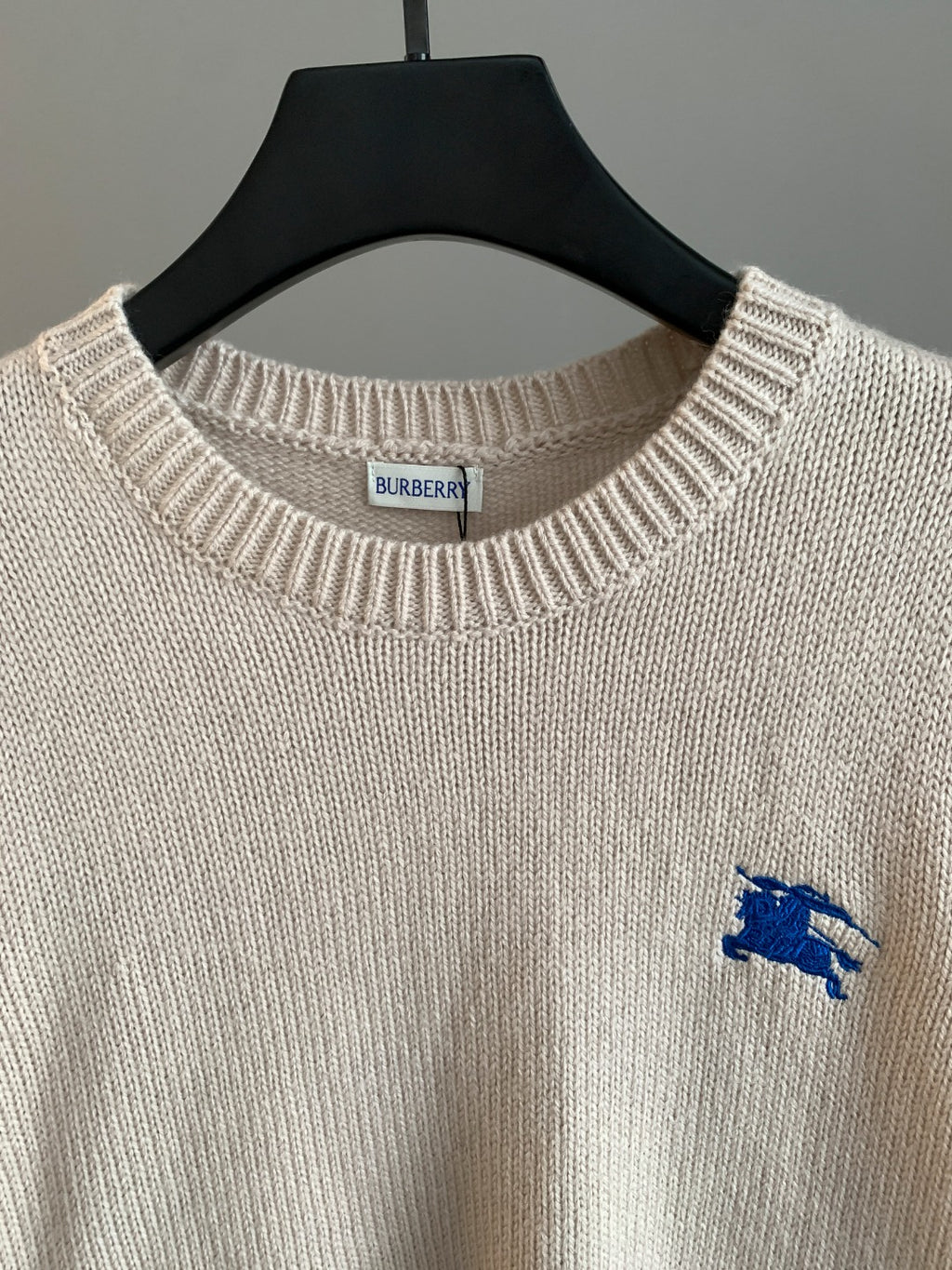 Burberry long sweater neckline close-up with blue horse logo
