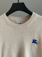 Burberry long sweater neckline close-up with blue horse logo