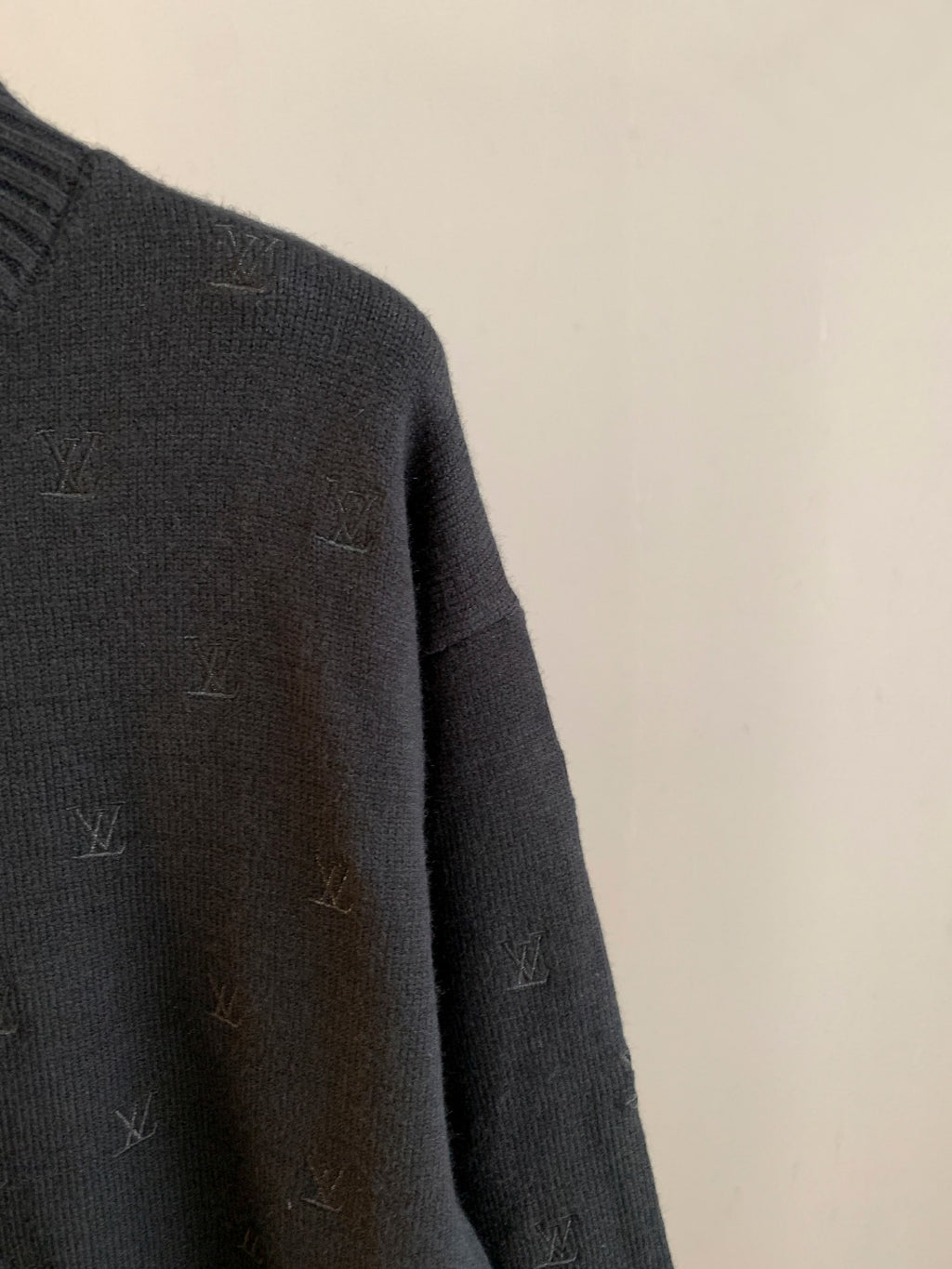 Dark knit sweater shoulder and sleeve with LV monogram detail