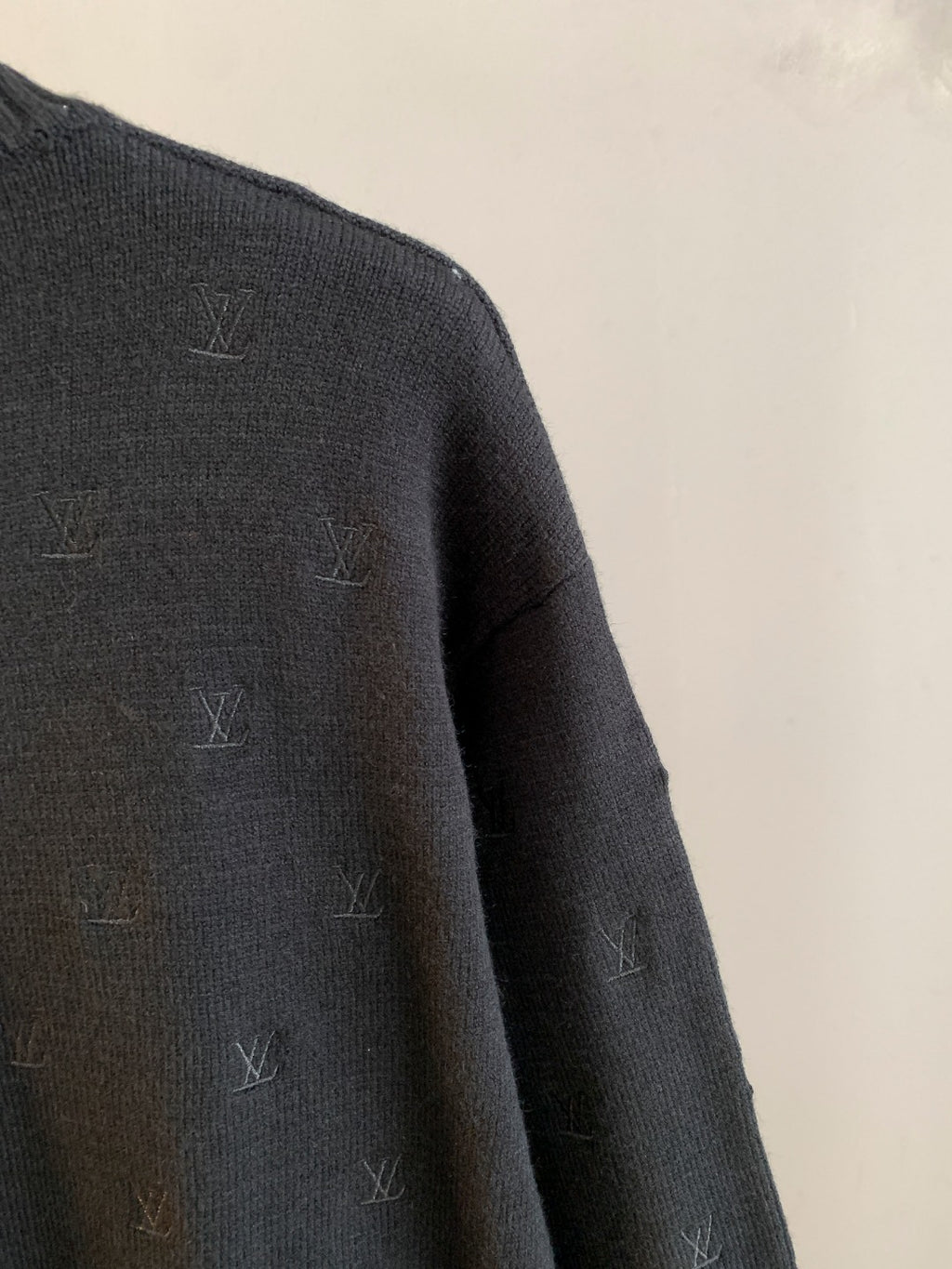 Dark knit sweater side with scattered LV monogram motifs, long sleeve