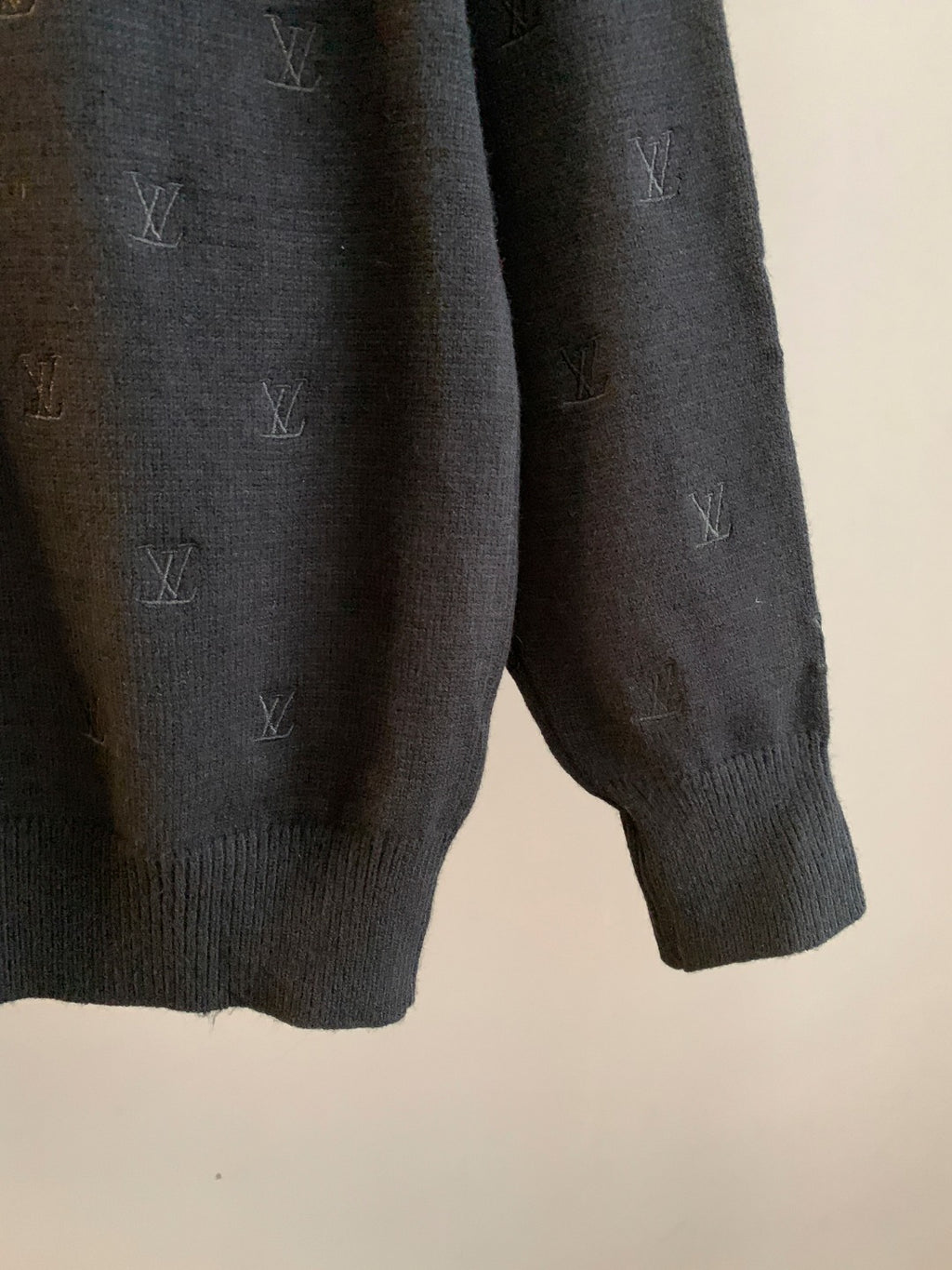 Dark knit sweater arm and cuff with ribbed finish and LV monogram pattern