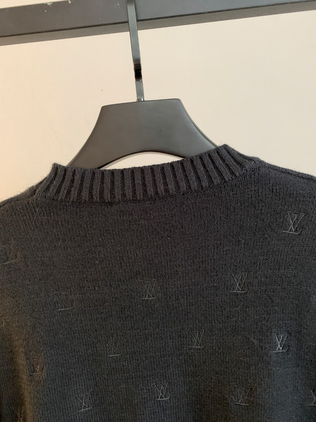 Dark knit sweater close-up of ribbed crew neck with LV monogram pattern