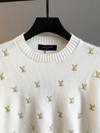 White knit crewneck with gold Louis Vuitton monogram pattern, close-up of neckline label