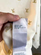 White knit sweater care label showing cotton content and parts warning