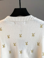 White knit sweater with gold Louis Vuitton monogram pattern, close-up of back yoke