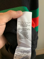 Gucci knit sweater care label with washing instructions on white fabric tag