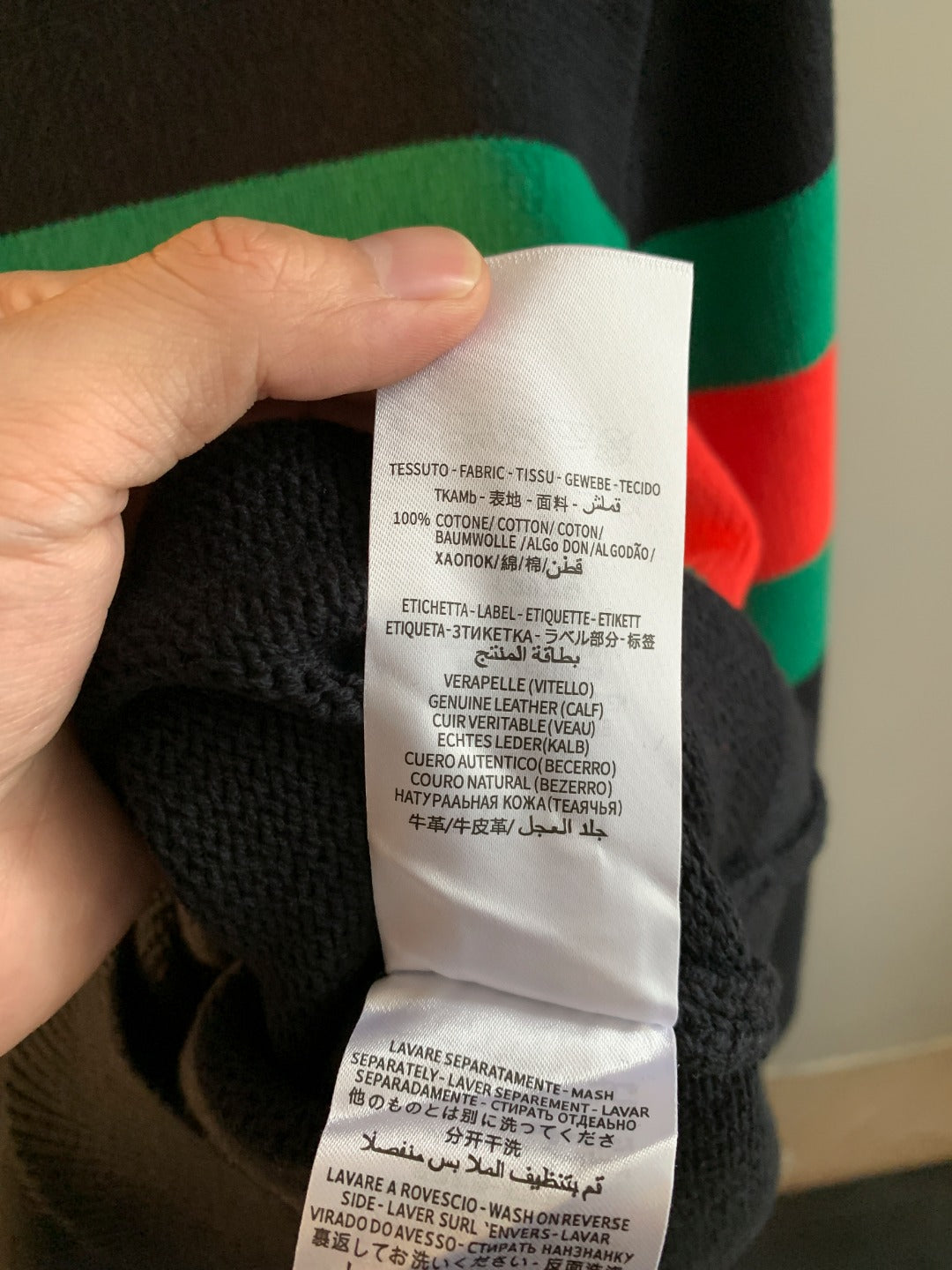 Gucci knit sweater care label with washing instructions on white fabric tag