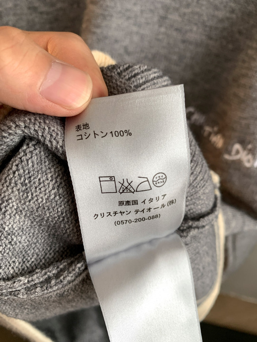 Gray knit sweater fabric care label on inside of collar