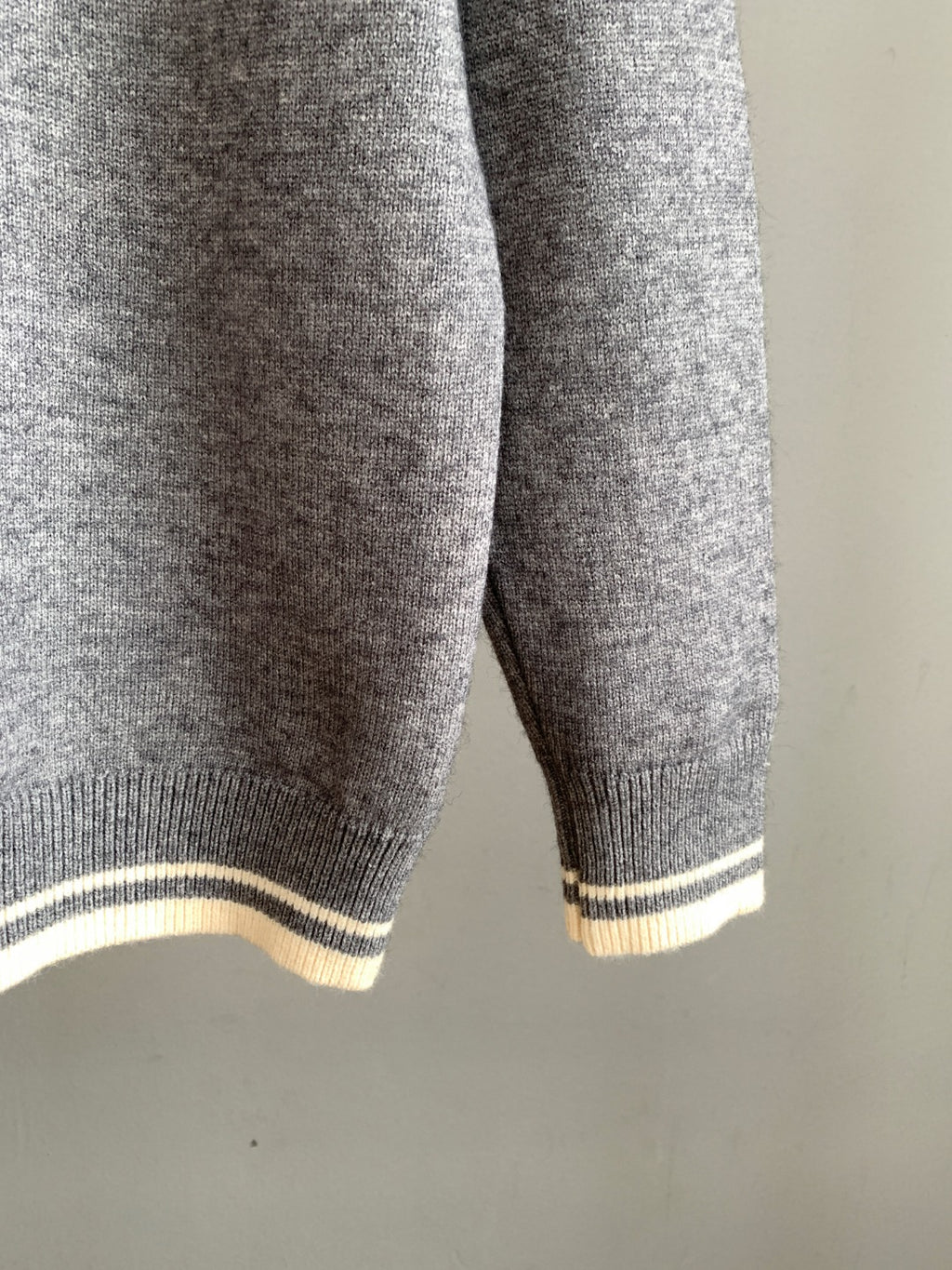 Gray knit sweater with striped ribbed hem and cuffs in light and dark bands
