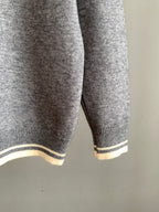 Gray knit sweater with striped ribbed hem and cuffs in light and dark bands
