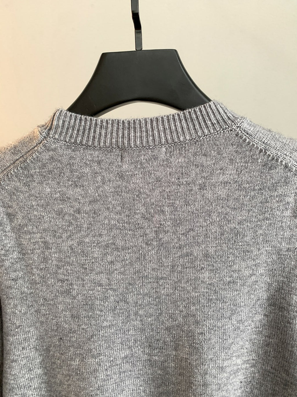 Gray knit sweater collar detail with ribbed crewneck on hanger