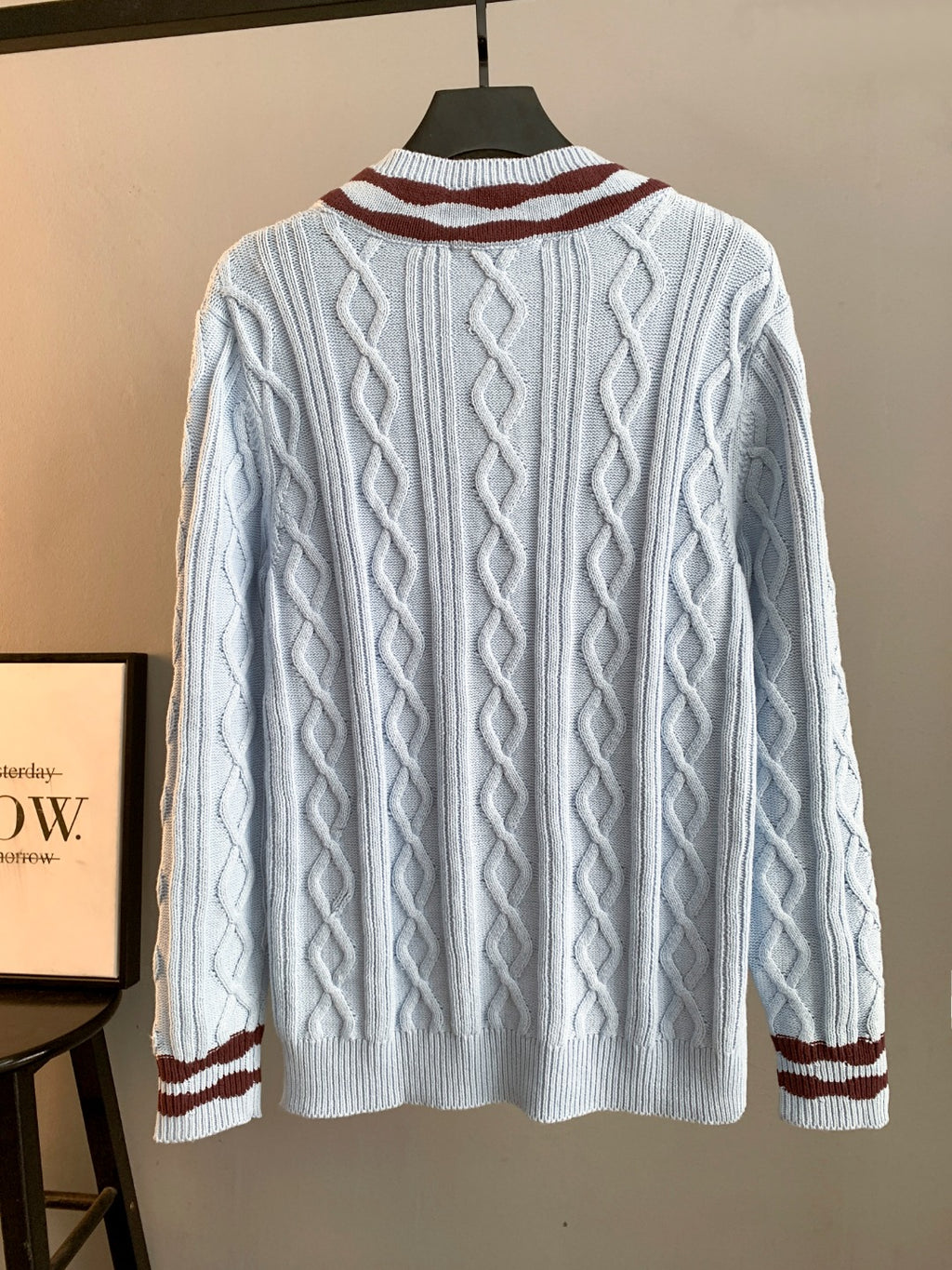 Long cable-knit sweater in light blue with dark red and white striped cuffs