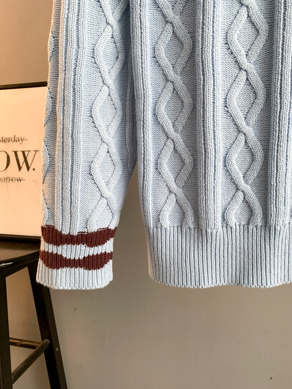 Light blue cable-knit long sweater hem and sleeve cuffs with burgundy-and-white stripes