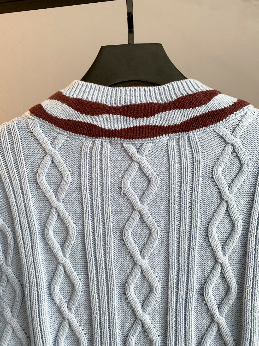 Light blue cable-knit long sweater back with burgundy-and-white striped neckline