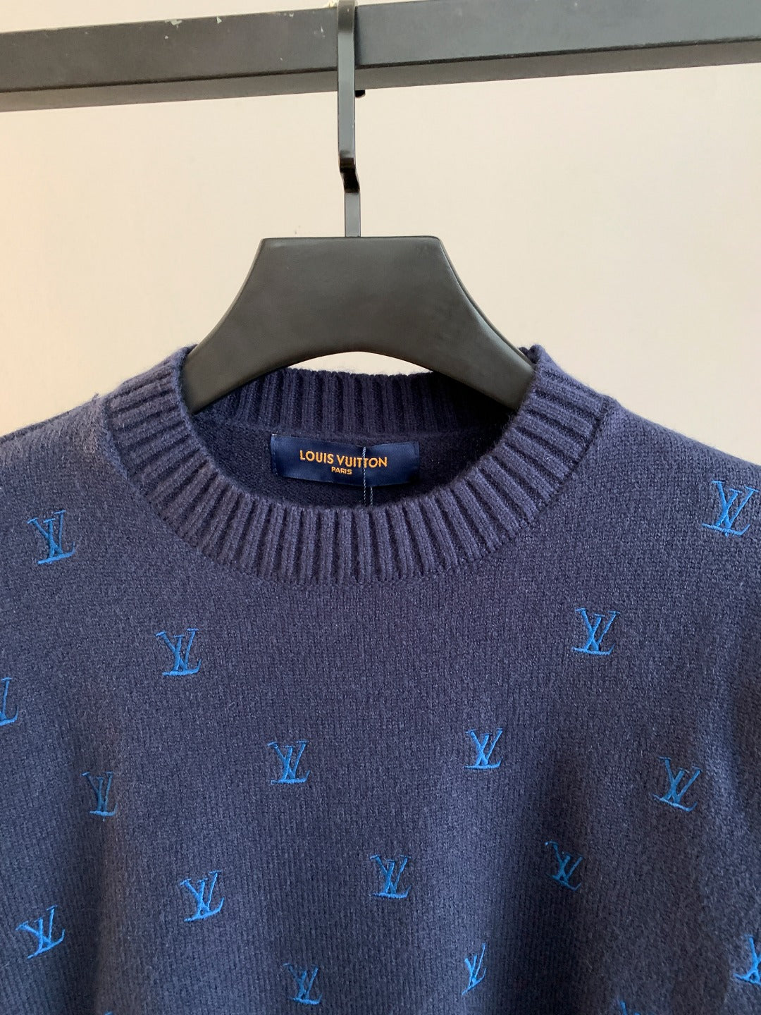 Dark navy knit sweater close-up of ribbed crew neck with Louis Vuitton logo patch