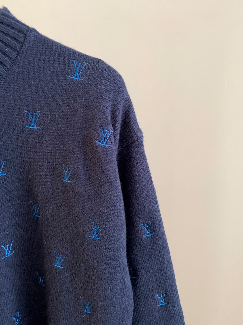 Dark navy knit sweater sleeve with blue Louis Vuitton monogram pattern