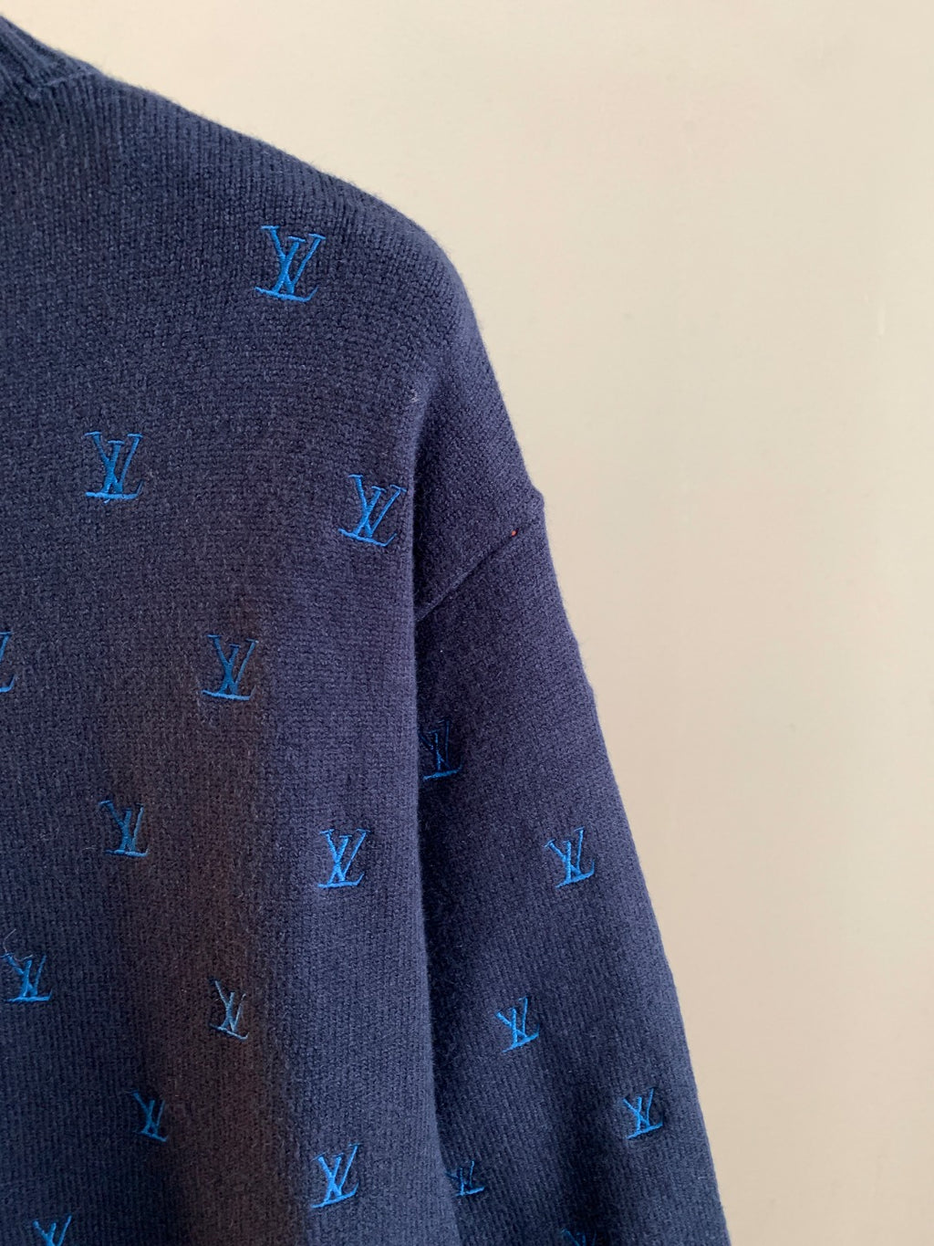 Dark navy knit sweater side close-up with blue Louis Vuitton monogram pattern