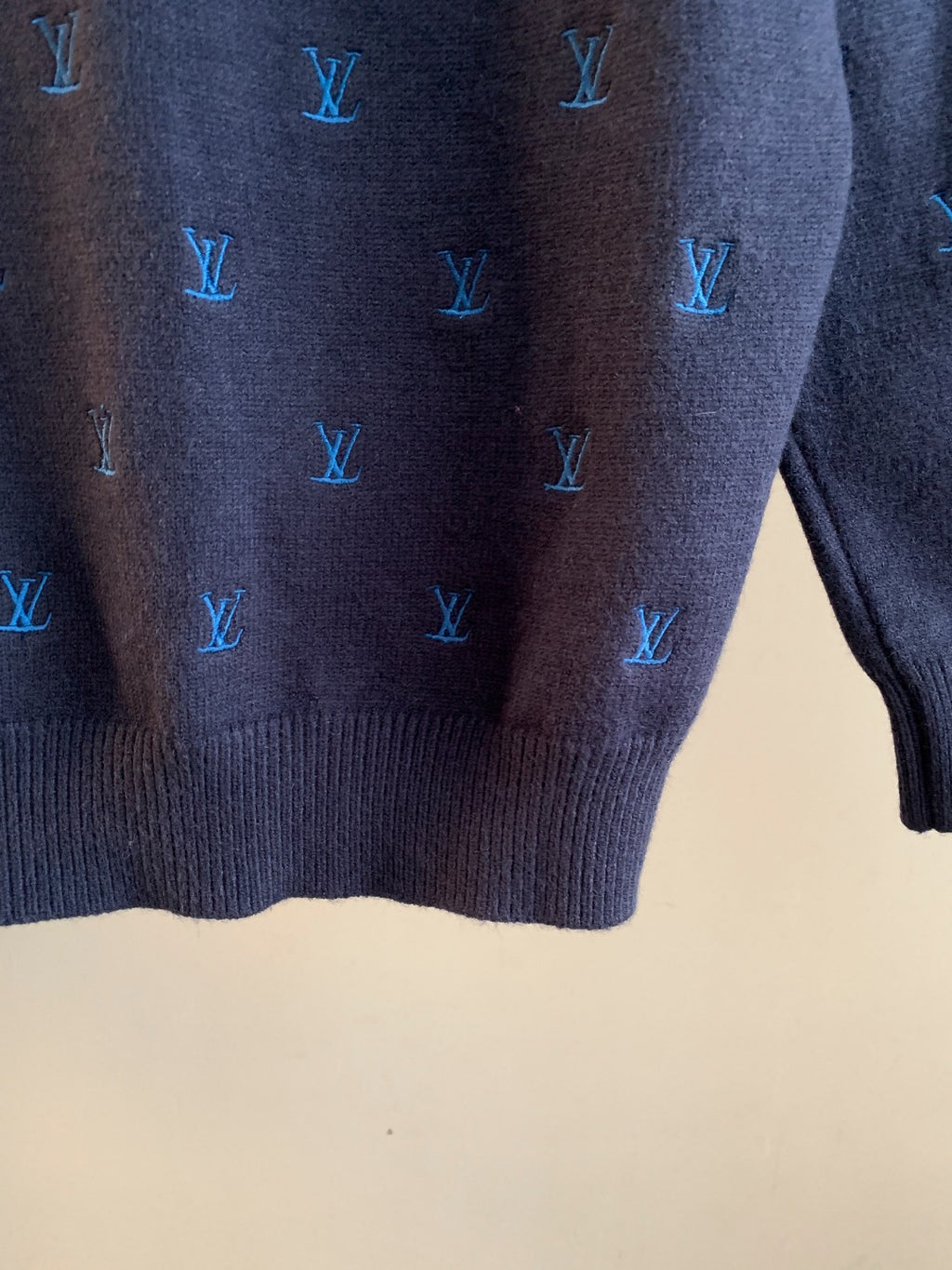 Dark navy knit sweater lower back close-up with blue Louis Vuitton monogram pattern