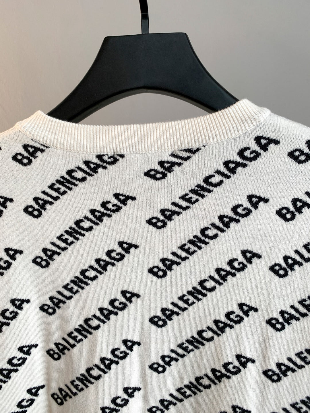 Cream knit sweater with repeating Balenciaga logo pattern and ribbed crew neck
