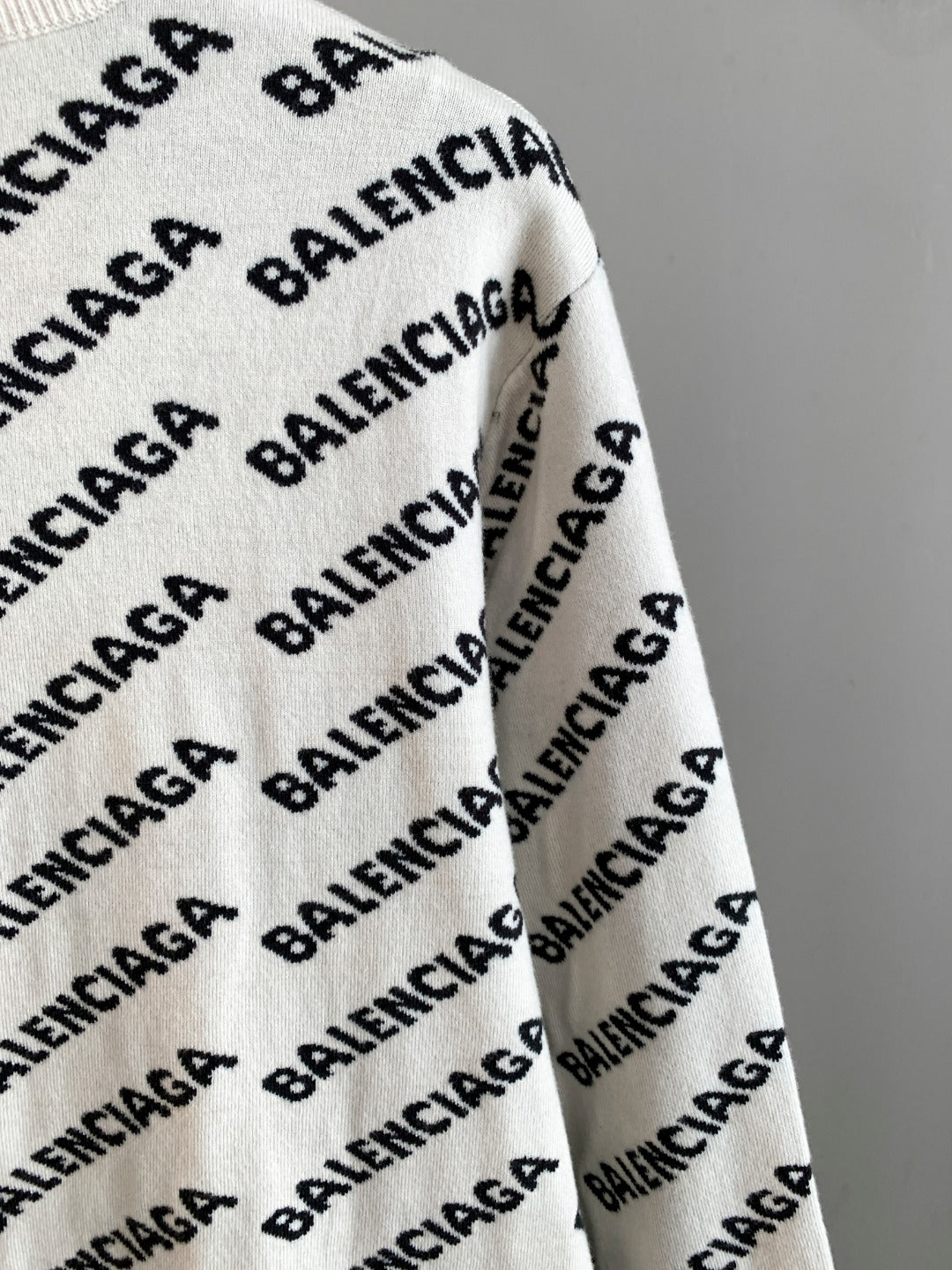 Long-sleeve sweater in cream with black BALENCIAGA logo pattern; side view