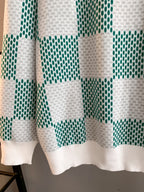 Sweater hem and lower sleeves in white with green check knit pattern
