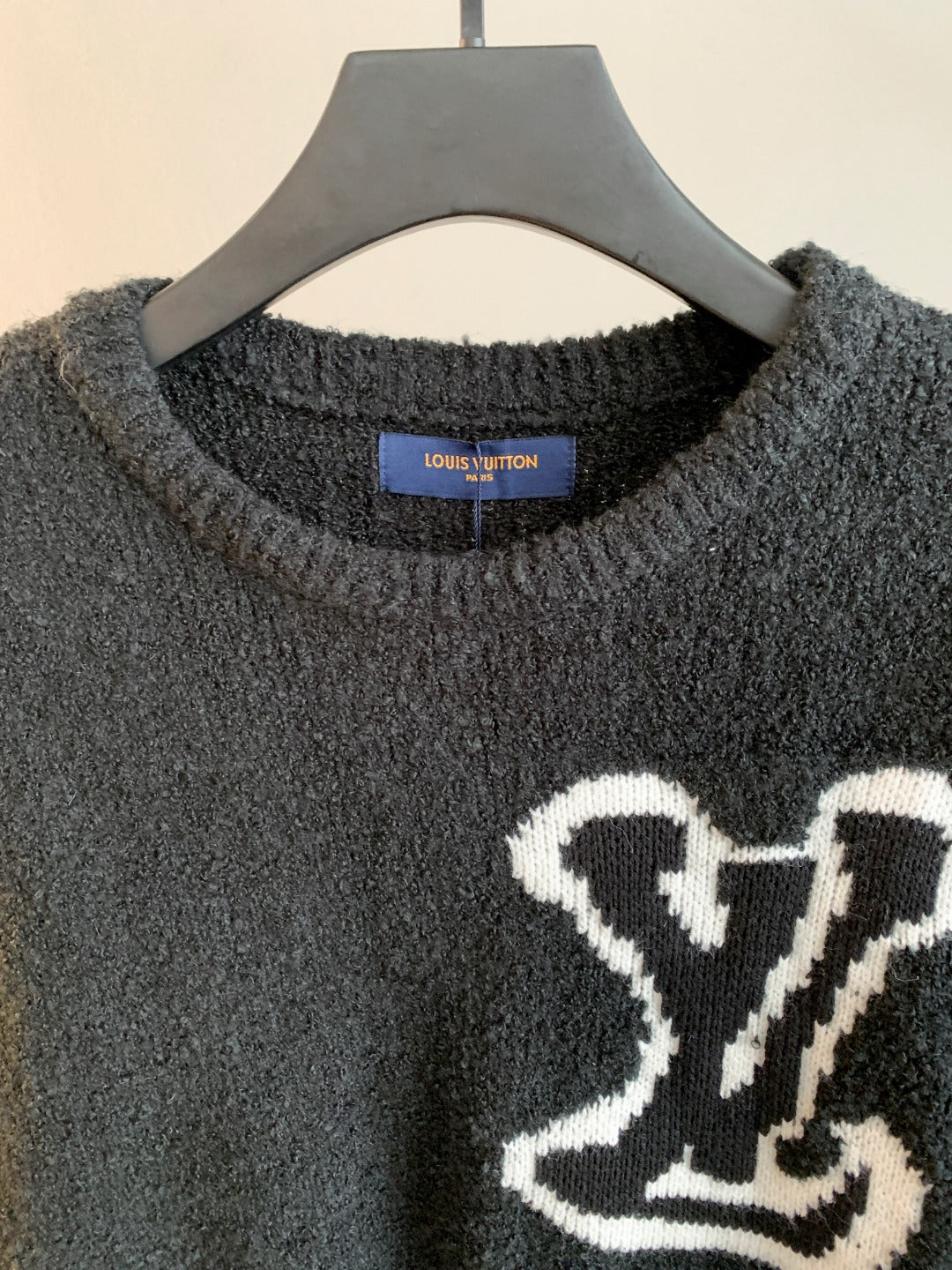 Louis Vuitton long-sleeve sweater neckline detail, dark charcoal with white emblem