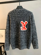 Long-sleeve sweater with speckled black and white knit, red logo patch on back