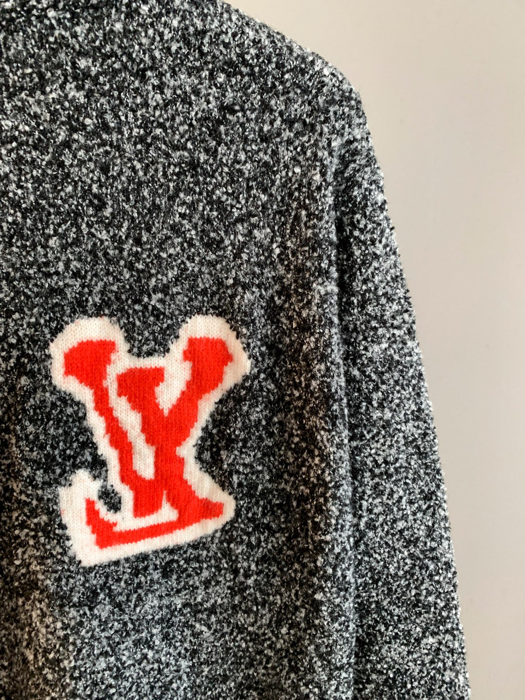 Louis Vuitton knit sweater side view with red LV logo patch and speckled knit