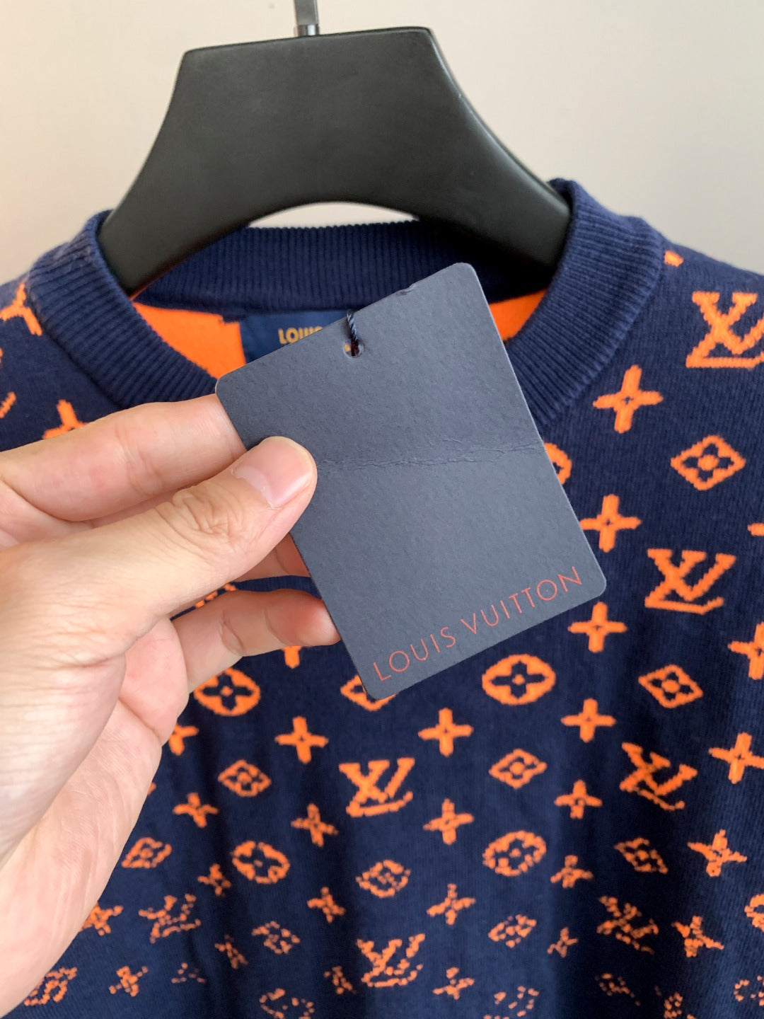 Louis Vuitton logo sweater care label on navy fabric with orange monogram print