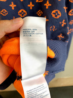 Fabric content label on orange-and-navy monogram sweater