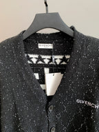 Black cardigan with contrasting patterned collar panel and two-button placket.