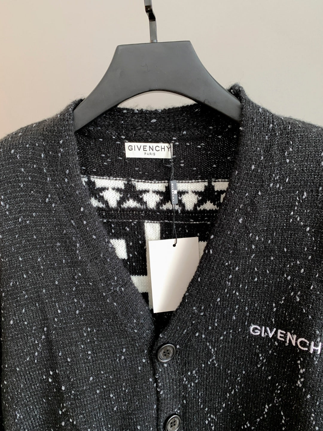 Black cardigan with contrasting patterned collar panel and two-button placket.